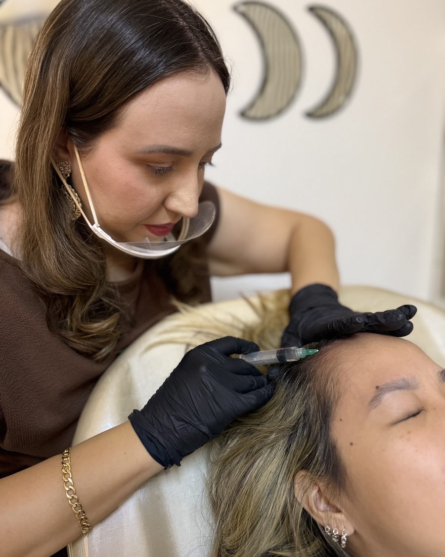 Giovana Vicentini realizando procedimento capilar em paciente